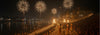 Diwali festival celebration with fireworks, devotees, and ceremonial lamps by a riverside ghat at night.