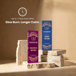 Sacred Wood and Rose Oudh premium incense stick boxes displayed on stone blocks, calm background.