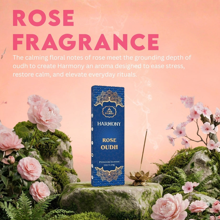 Rose Oudh incense sticks box with incense holder, surrounded by pink roses on mossy rocks, pink background.