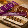Premium incense sticks on stone slab with Mystic Sandal and Sacred Wood packaging, aromatic setting
